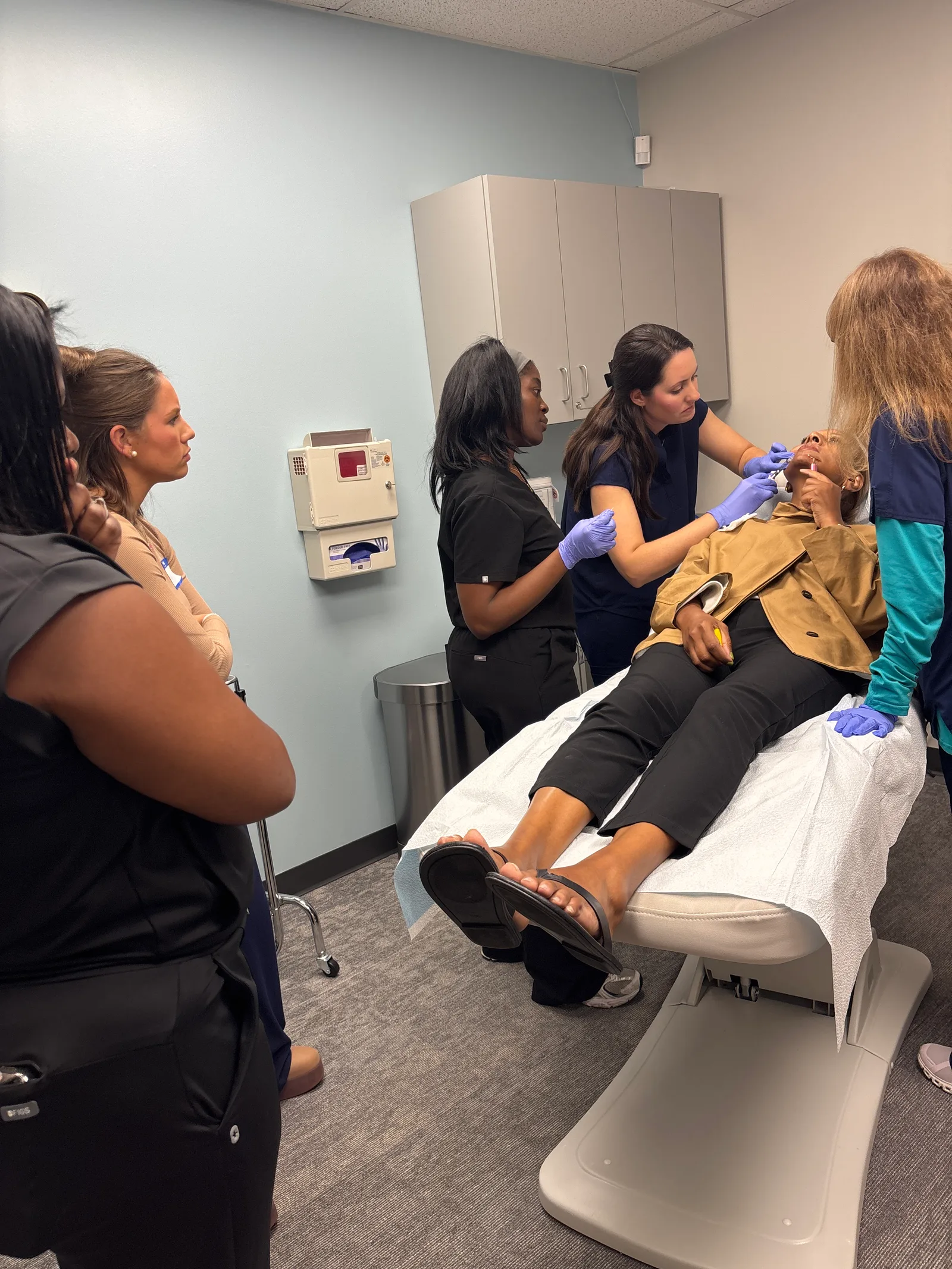 A student practices with a live model and instructor guidance in Atlanta