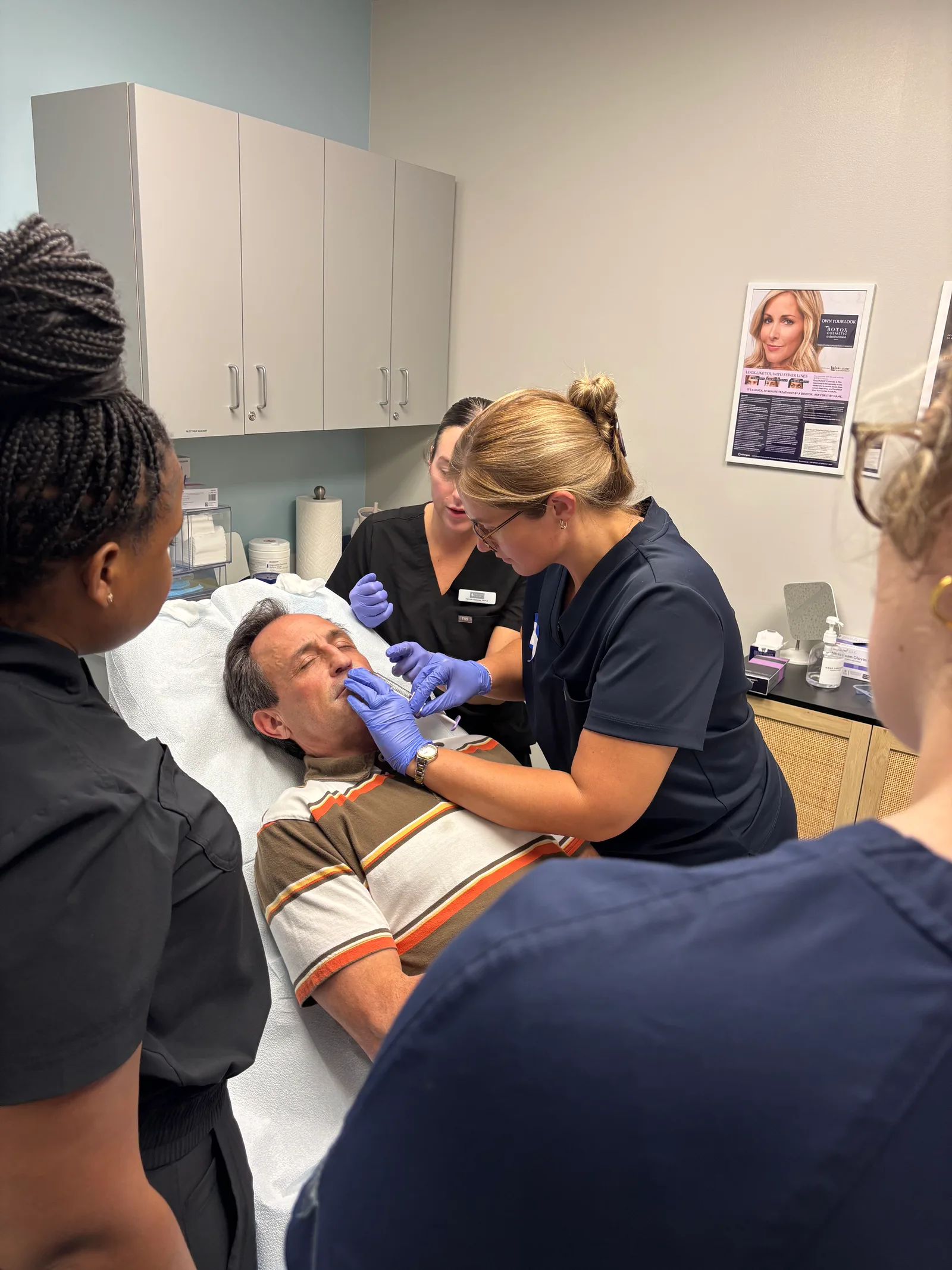 A student injects a live model with instructor guidance
