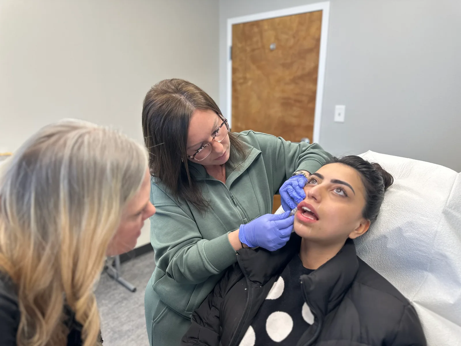 A NEXT STEP participant practices with a live model and an instructor beside her in Atlanta