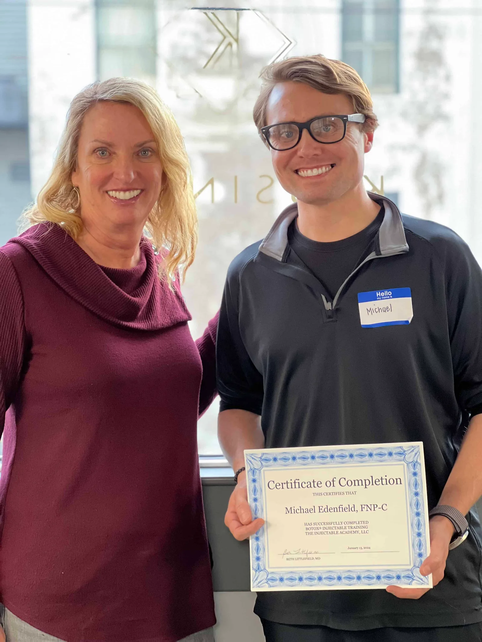 A Savannah graduate displays a certificate with an Academy instructor